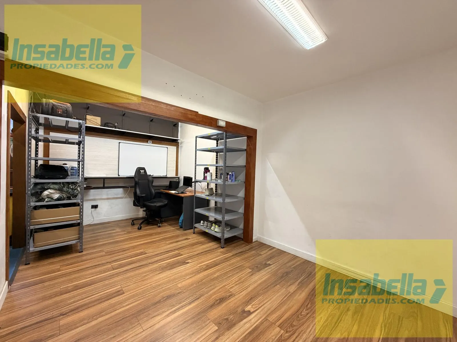 Oficina privada con piso de madera y pizarra para planificación