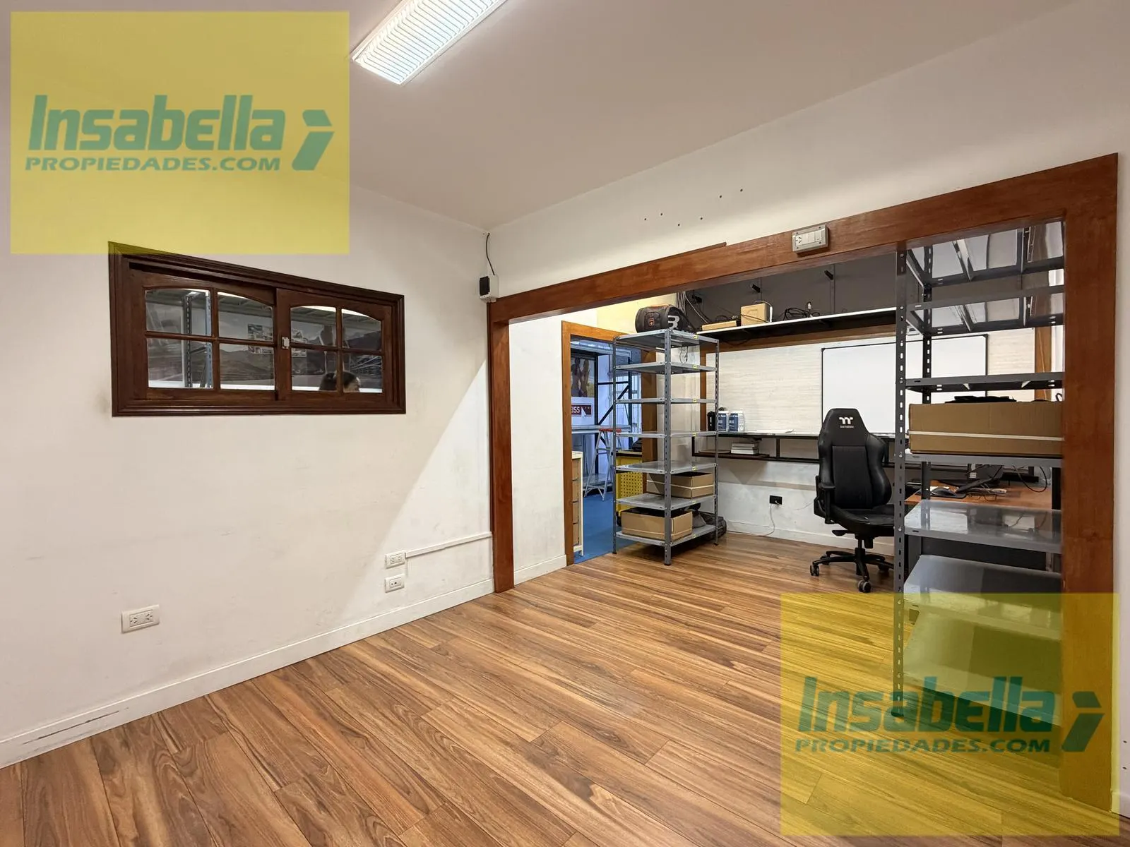 Oficina privada con ventanal interno que comunica con el depósito