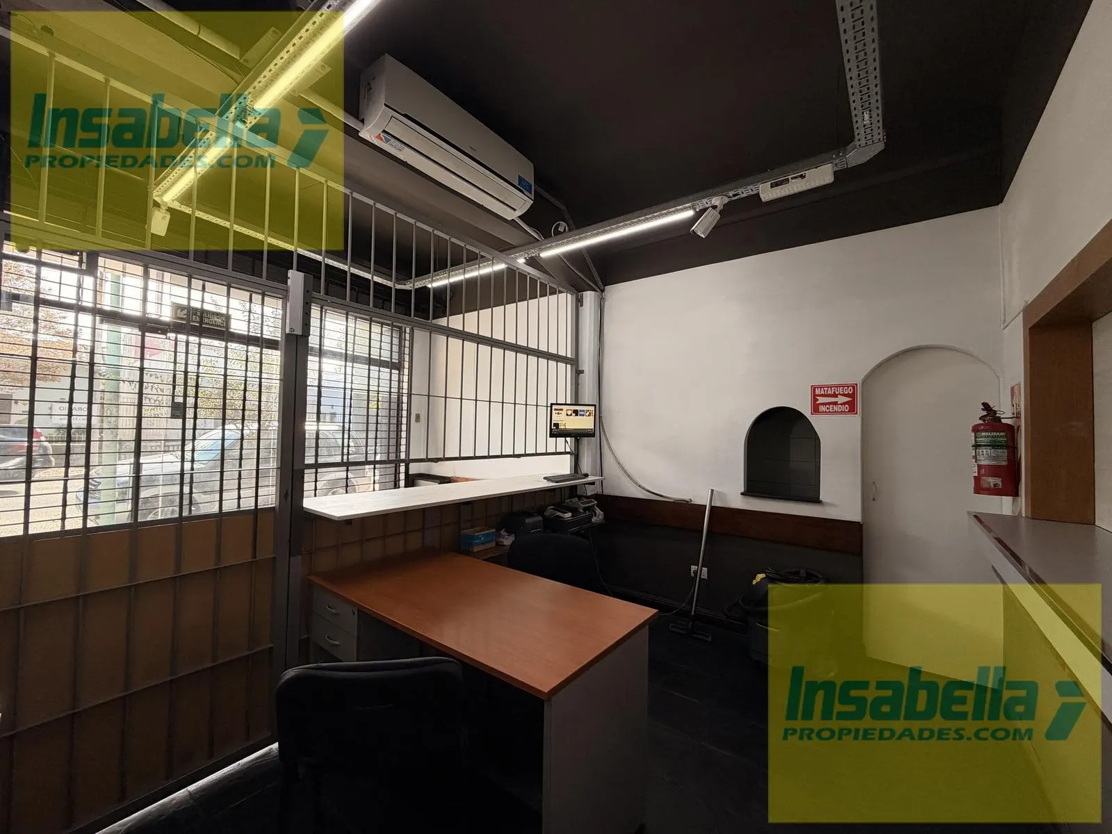 Oficina administrativa al frente con ventanal hacia la calle y aire acondicionado