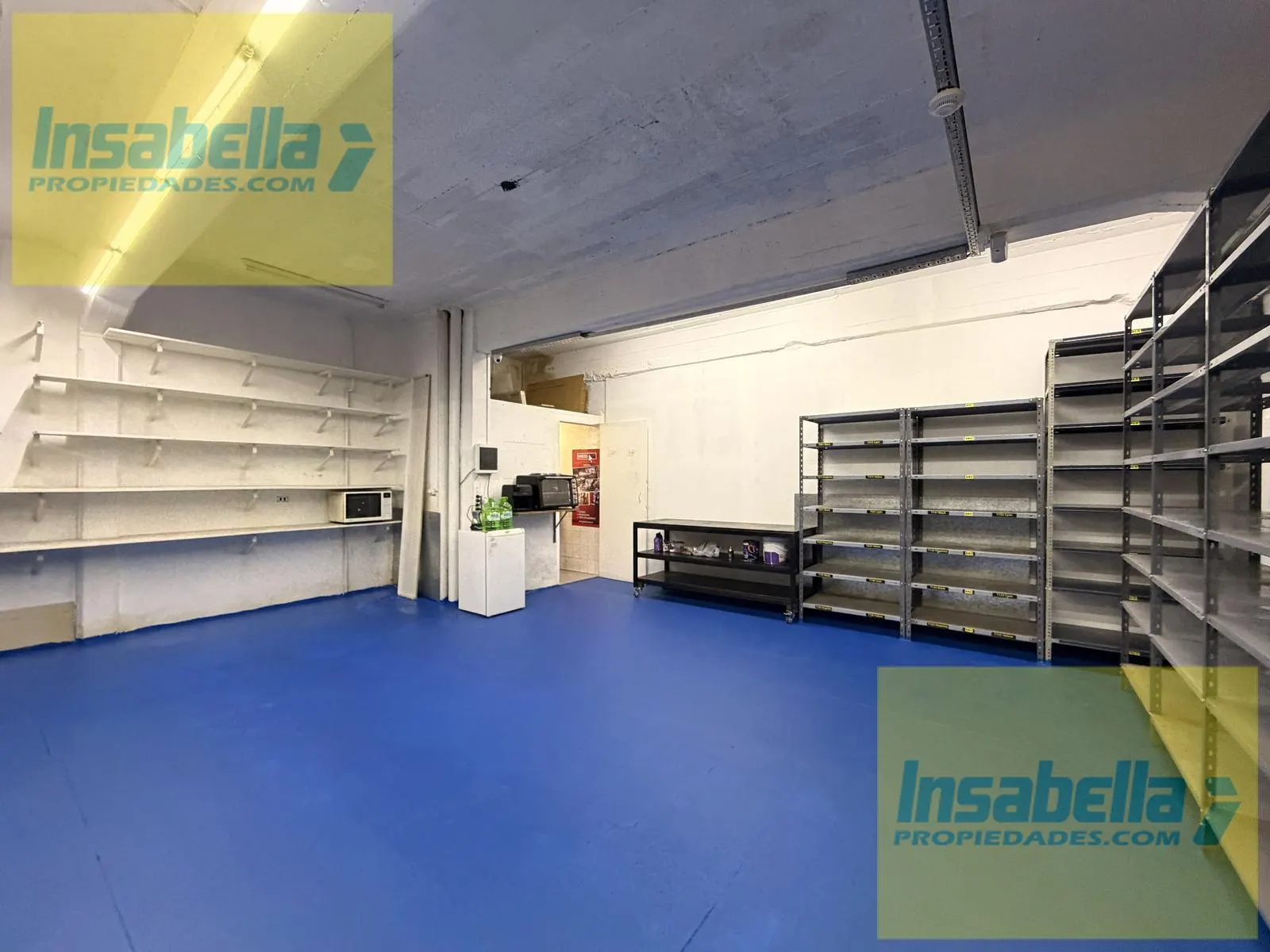 Depósito con piso pintado y estantería metálica perimetral