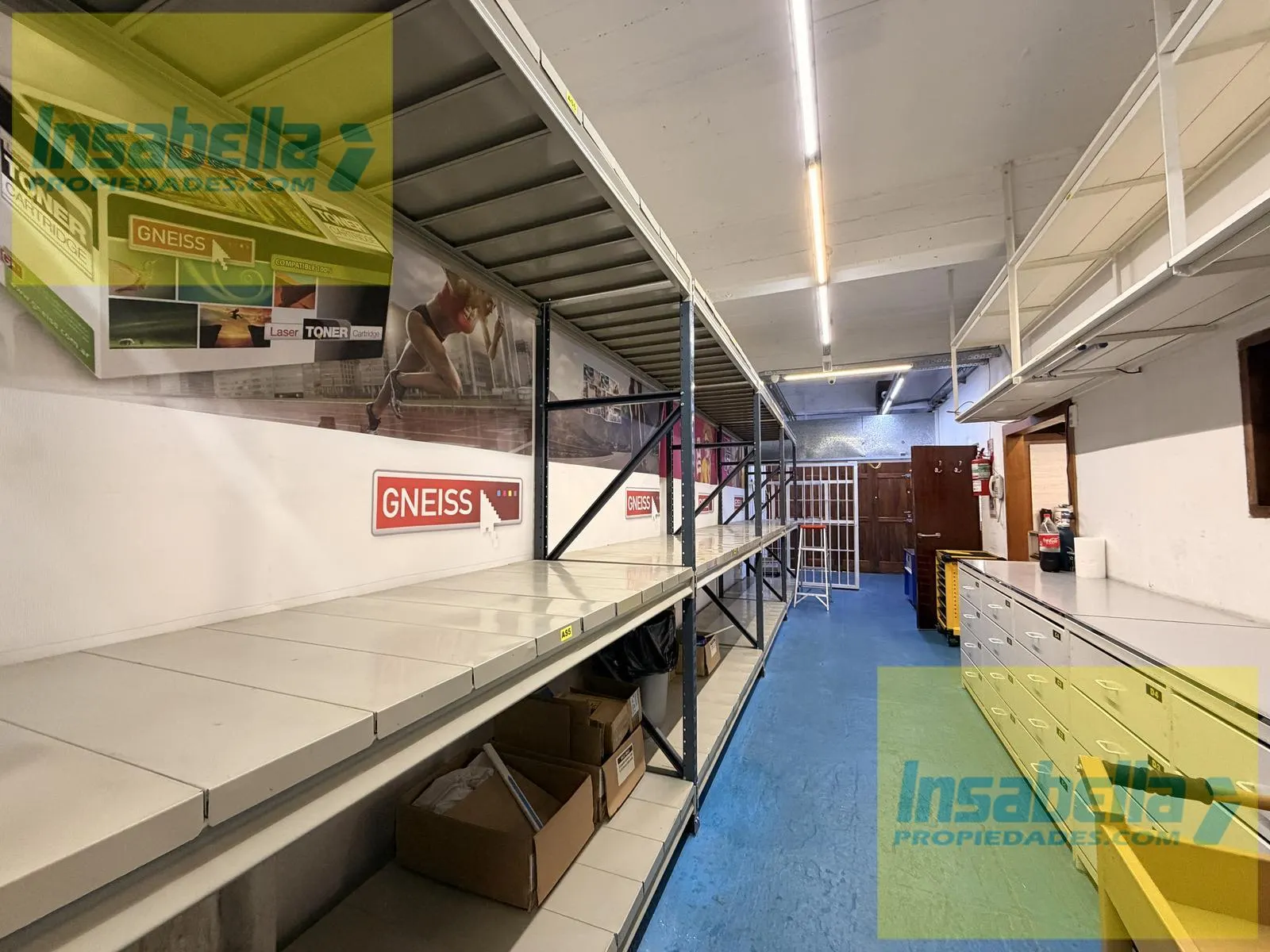 Sector posterior del depósito con estanterías y cartelería del inquilino saliente